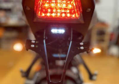 In der Nahaufnahme eines silber-schwarzen Motorrads ist deutlich ein rotes Rücklicht zu erkennen.

Motorrad, Rot, Rücklicht, Nahaufnahme, Silber, Schwarz.