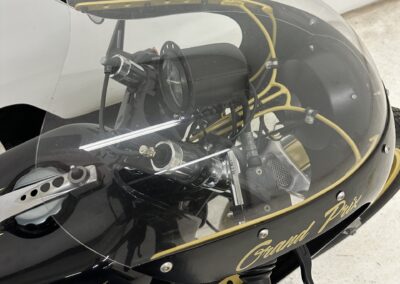 Ein schwarz-goldenes Motorrad mit klarer Windschutzscheibe.